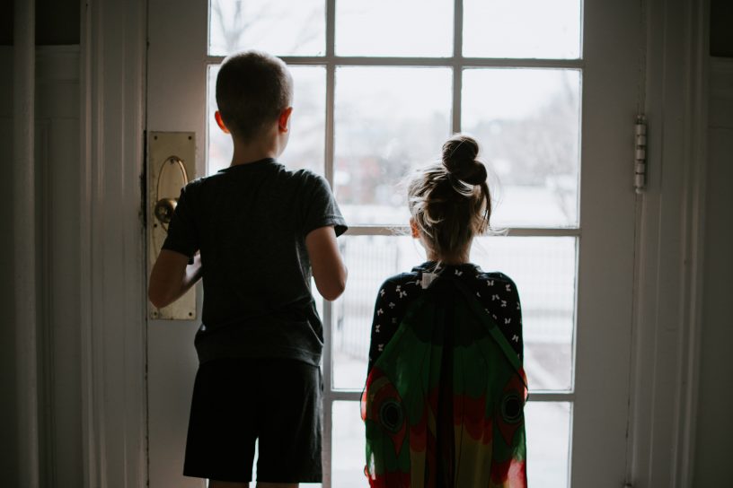Zwei Kinder vor einem Fenster