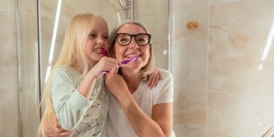 Zahngesundheit: Eine Frau und ein Mädchen beim Zähneputzen