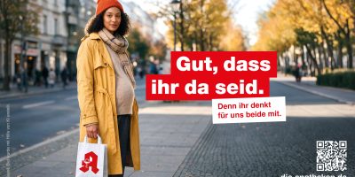 Schwangere steht mit einer Tüte aus der Apotheke auf der Straße